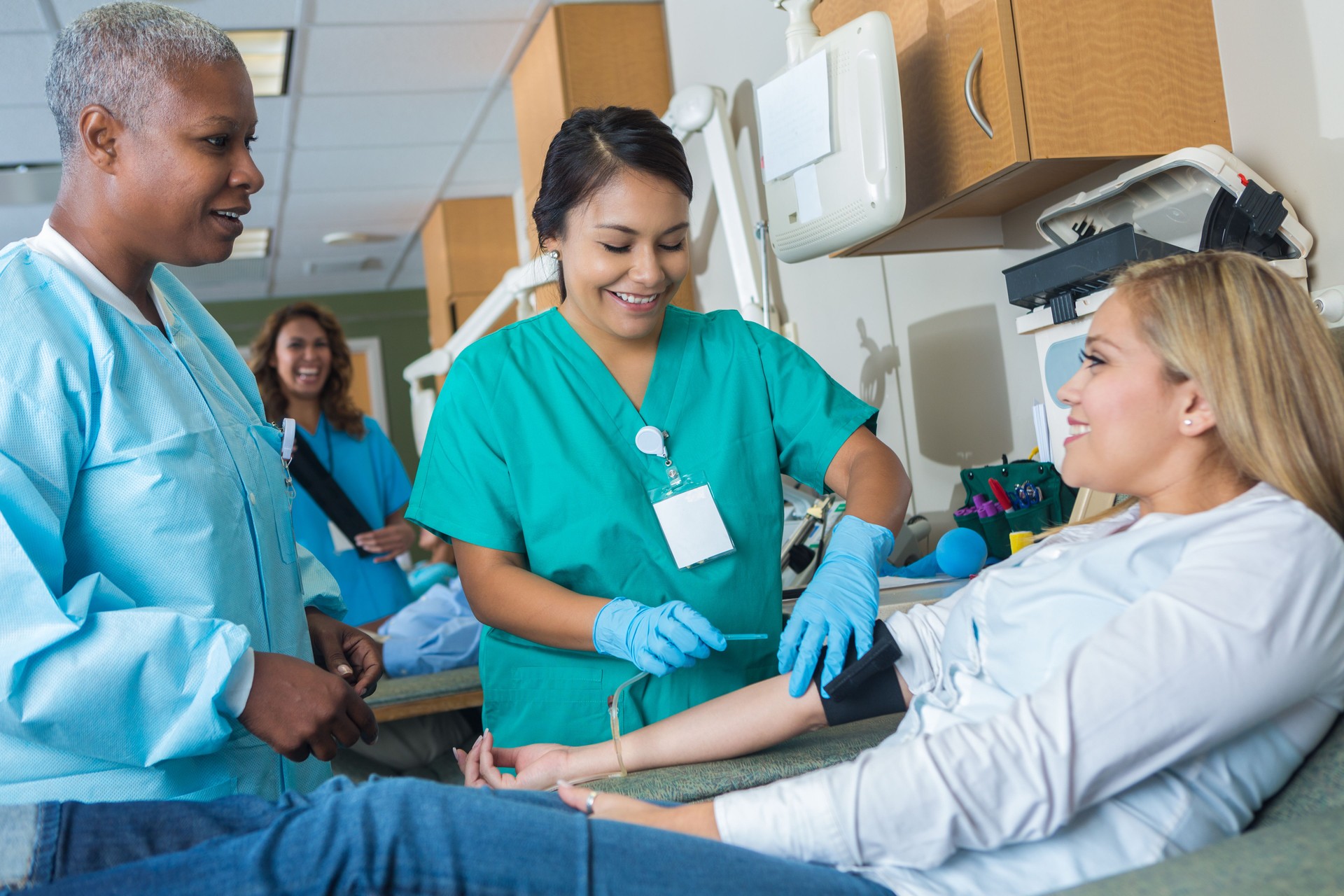 Medical intern learns how to draw blood from blood donor